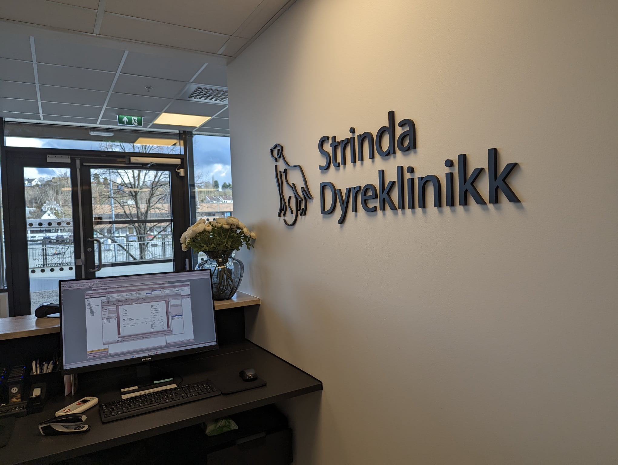 Resepsjonsdisken med klinikkens navn på veggen